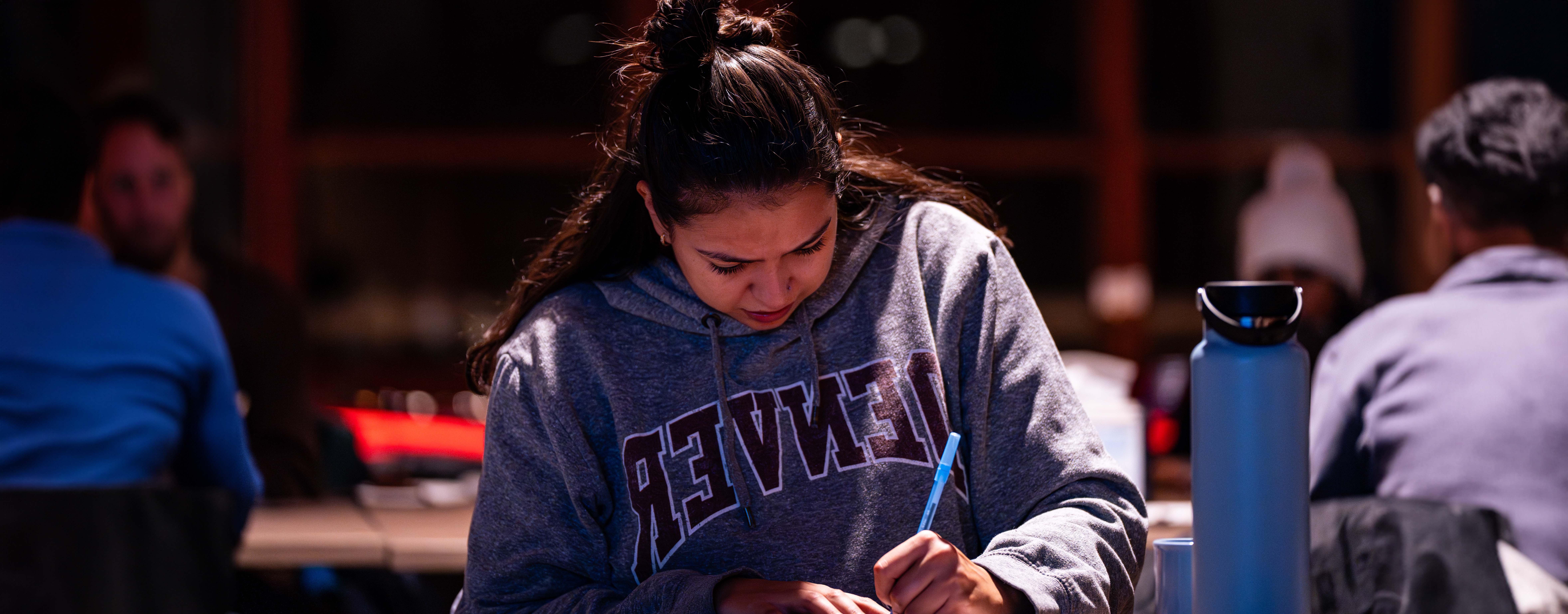 student taking notes in the dining hall