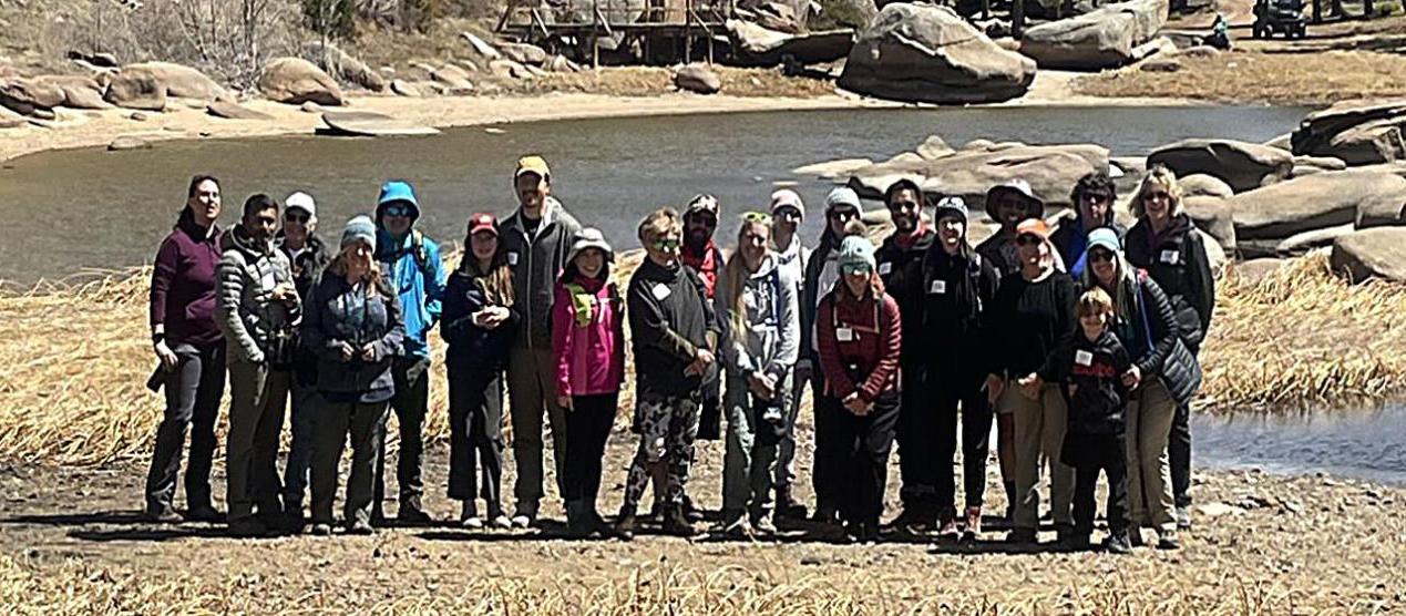 group posing next to water and rocks