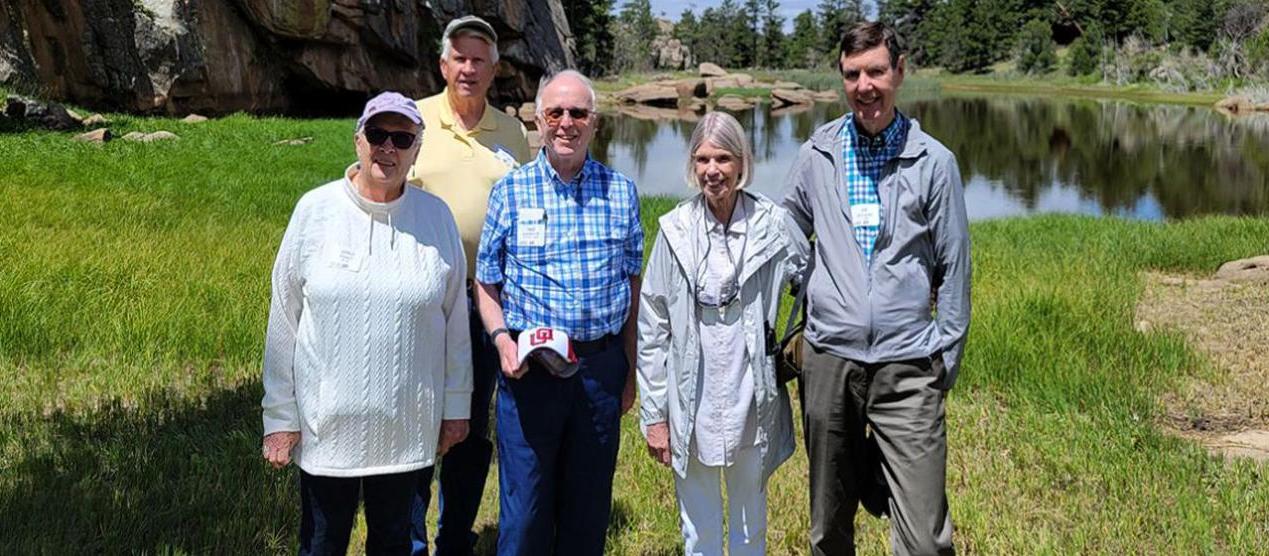 group posing next to lake and rocks